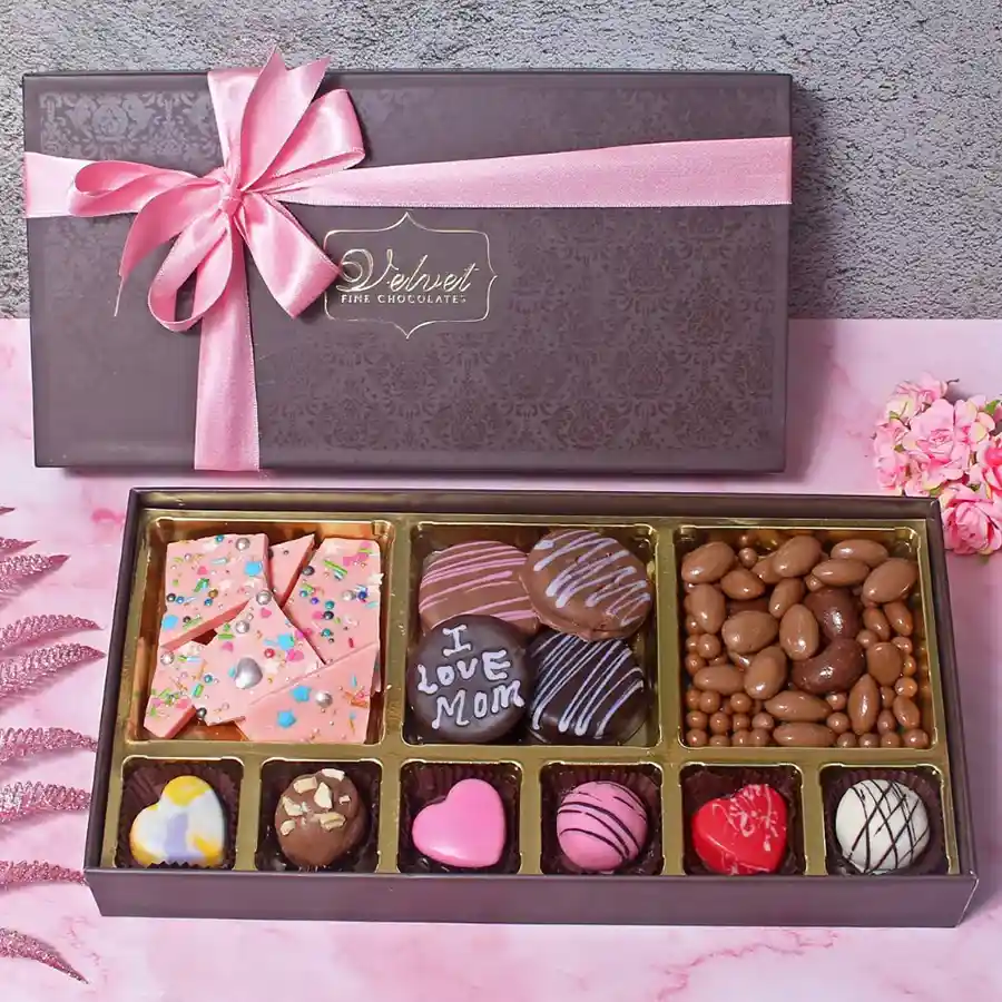 A beautifully arranged gift basket filled with assorted chocolates, Oreo cookies, coated nuts, and chocolate bark, perfect for Mother's Day.