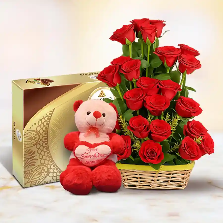 A romantic arrangement of 25 red roses with a teddy bear and Ferrero Rocher chocolates in a basket.