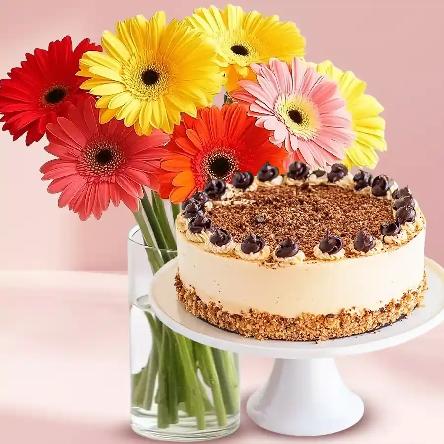 A vibrant vase of mixed Gerberas and a half-kilogram butter scotch cake on display.