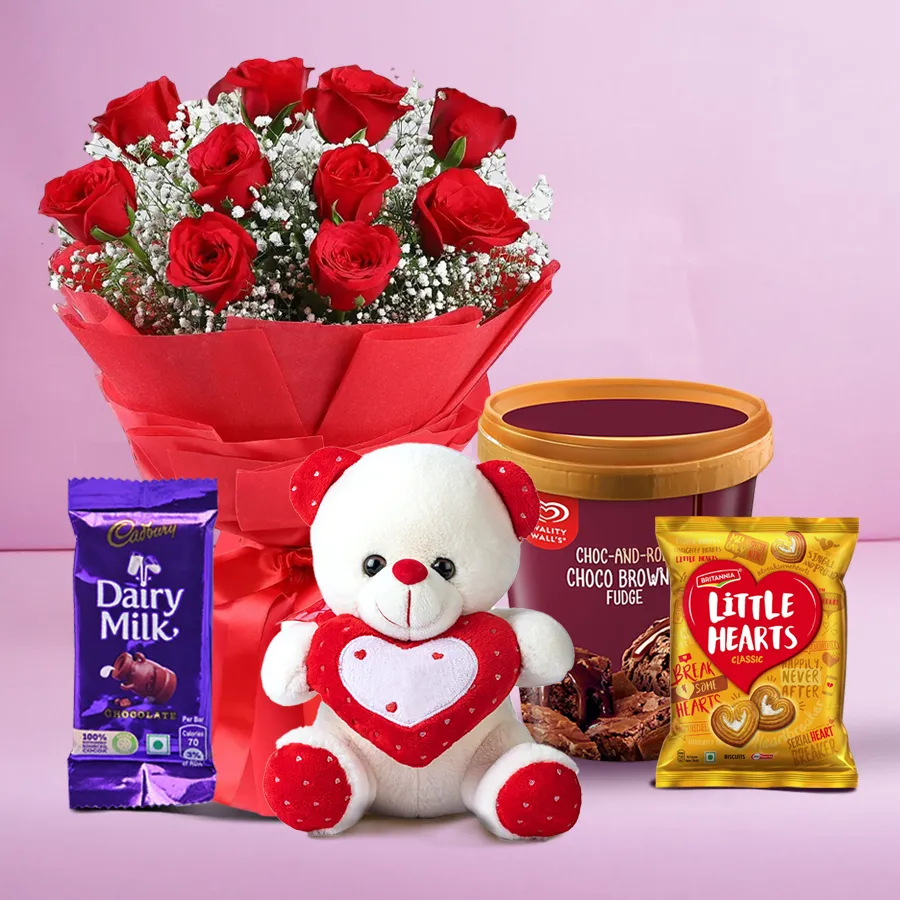 A vibrant gift hamper featuring a bouquet of red roses, ice cream, cookies, a teddy, and chocolate.