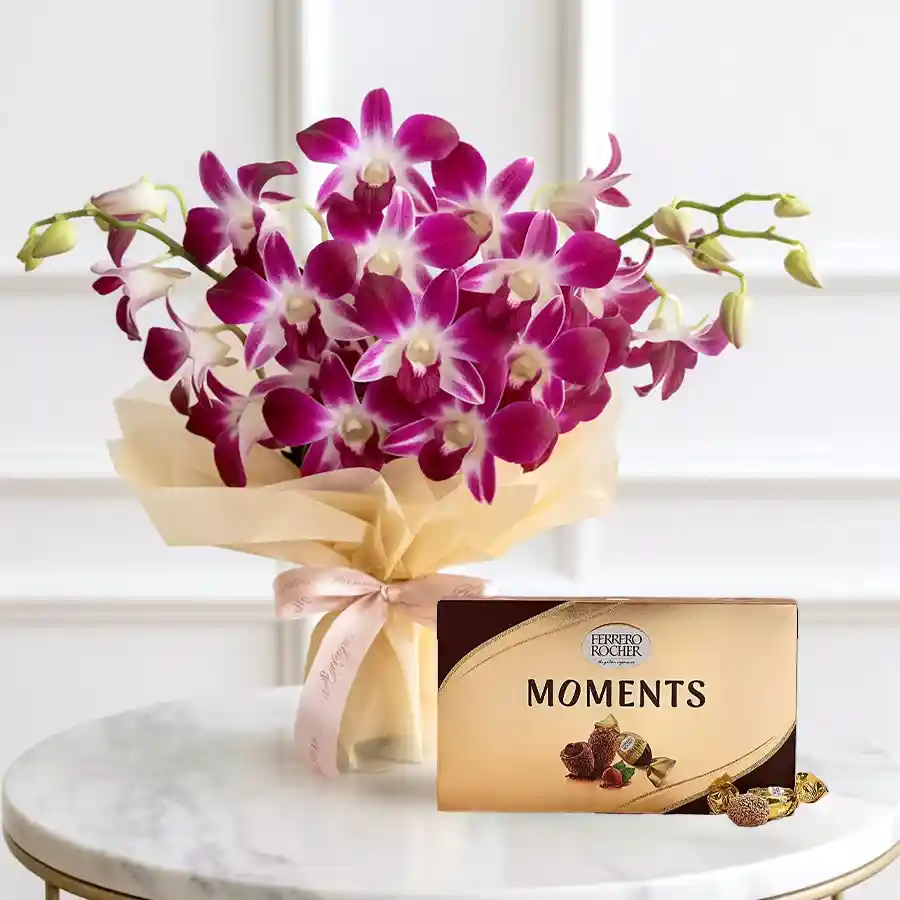 A vibrant bunch of six purple orchids accompanied by a Ferrero Rocher Moments chocolate box.