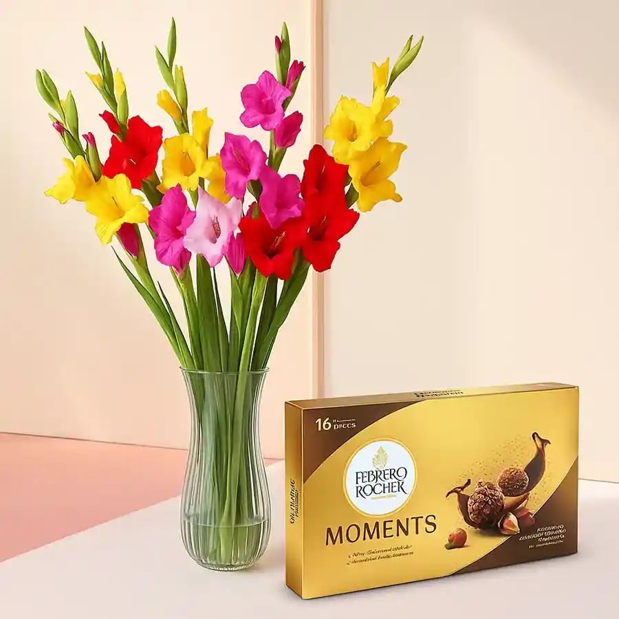 Assorted gladiolus in a glass vase with Ferrero Rocher chocolates.