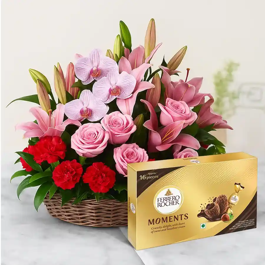 A beautiful arrangement of 30 flowers including pink anthuriums, asiatic lilies, orchids, and red carnations, accompanied by a box of Ferrero Rocher chocolates.