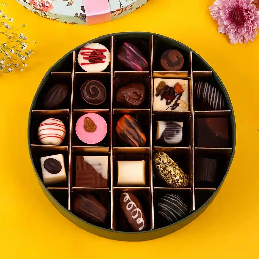 A beautifully arranged selection of assorted chocolates in various shapes and flavors, featuring milk and white chocolate, truffles, and fruity fillings, in a festive presentation for Diwali.
