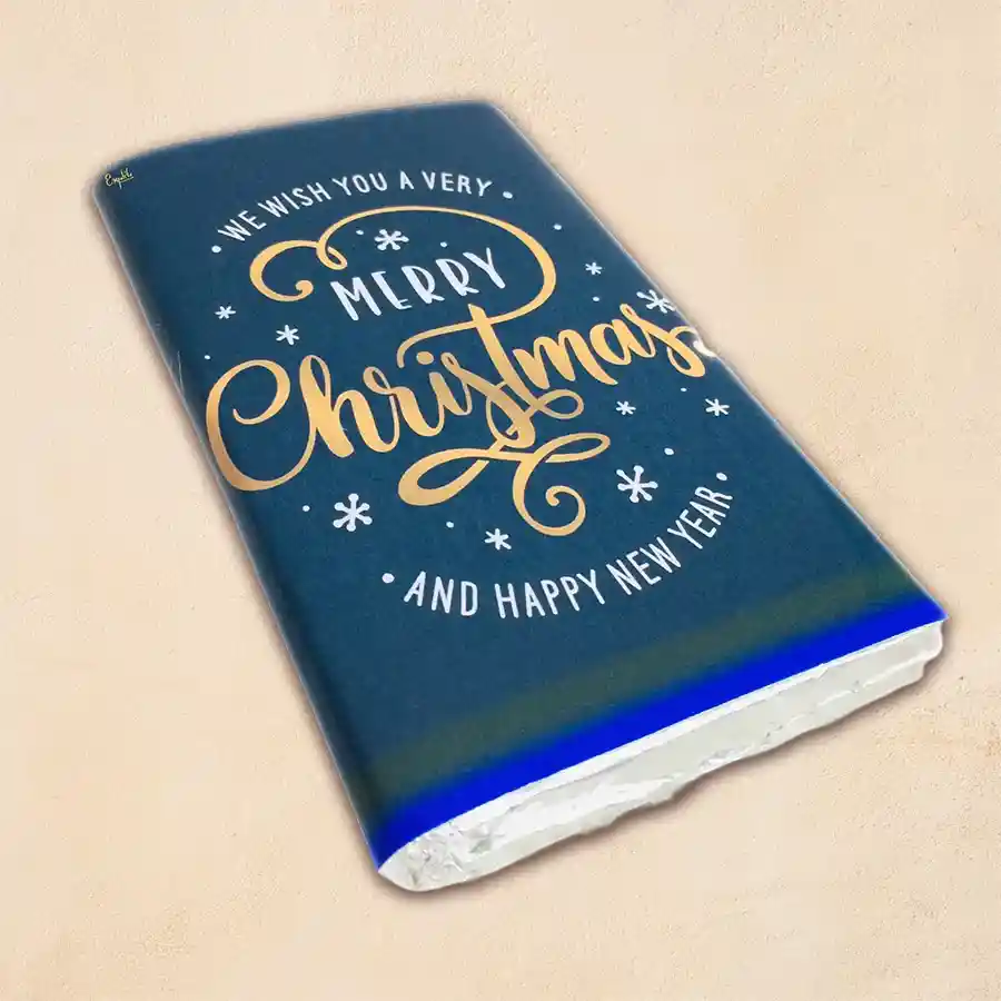 Seasons Greetings Roasted DryFruits Chocolate Bar wrapped in festive design with assorted roasted dry fruits and chocolate on display.