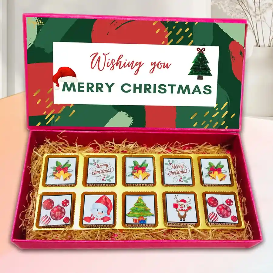 Box of assorted chocolates with festive flavors, featuring a Christmas-themed design and a variety of fillings including roasted dry fruit, cranberry, paan, butterscotch, mixed fruits, and chocochip.