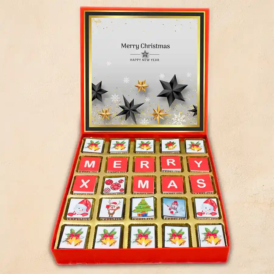A beautifully designed box of assorted chocolates featuring festive Christmas and New Year prints, showcasing various flavors including roasted dry fruit, cranberry, paan, butterscotch, mixed fruits, and chocochip fillings.