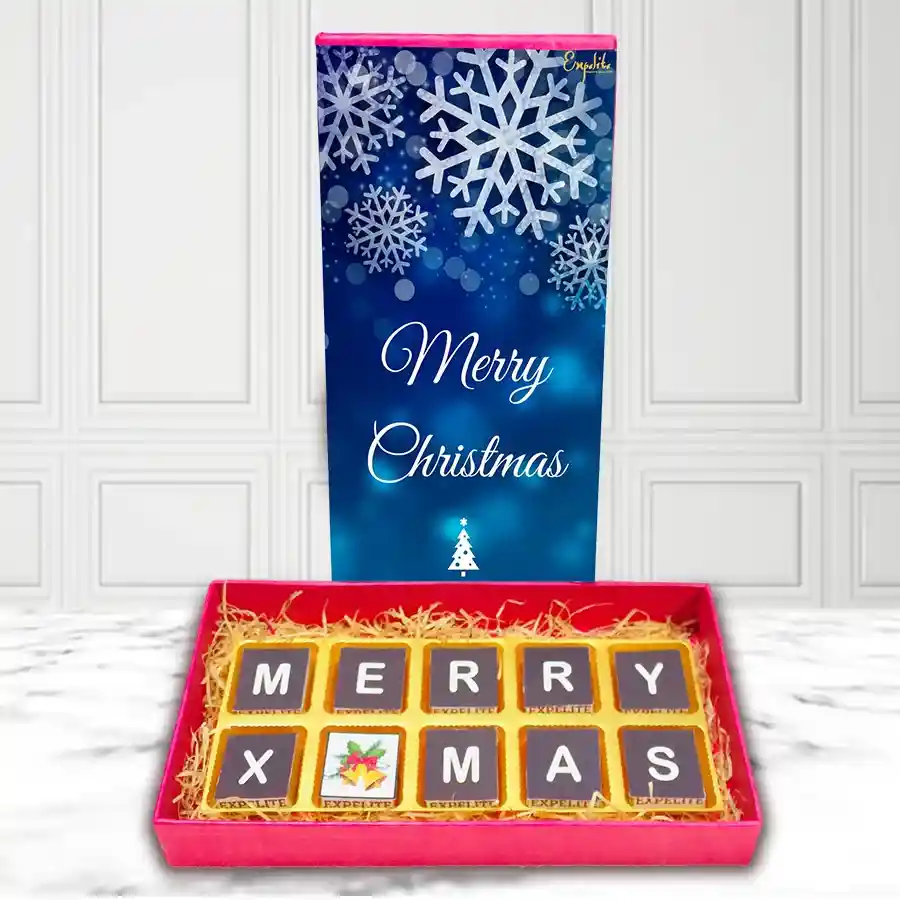 Exquisite Assorted Chocolates Box featuring festive Merry Christmas designs and a variety of flavors on a grassy base.