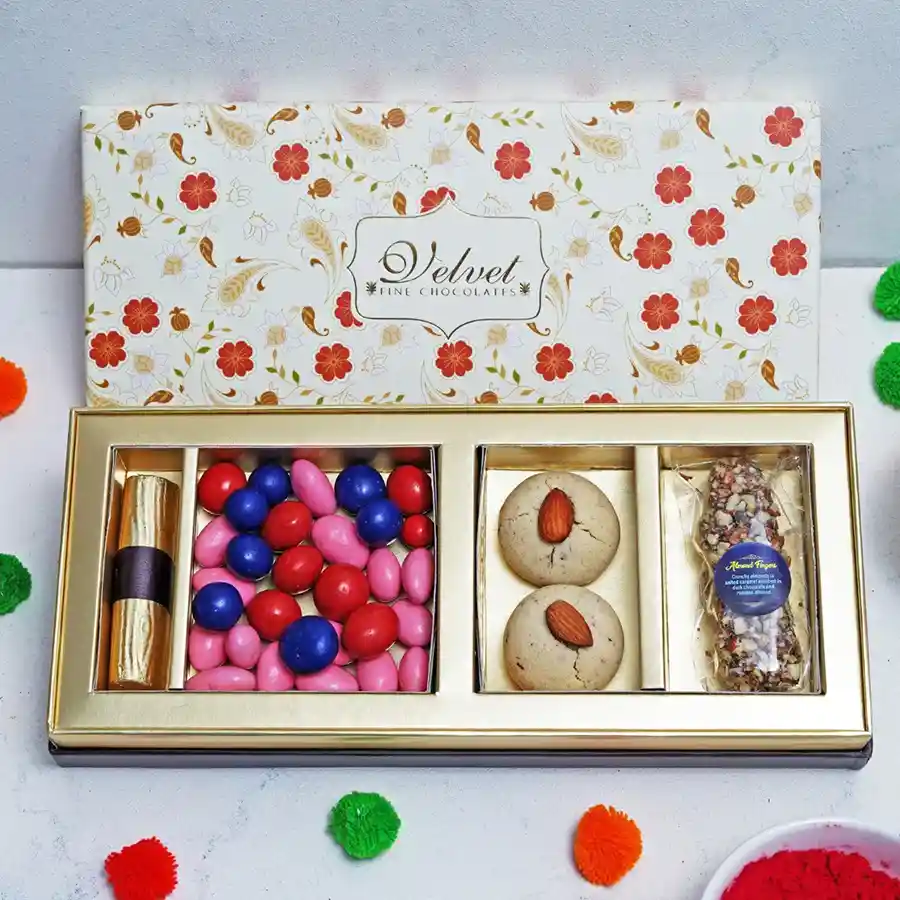 A vibrant assortment of chocolates including Strawberry Crisp Logs, Almond Fingers, assorted dragees, and Nankhatai cookies in an elegant box.