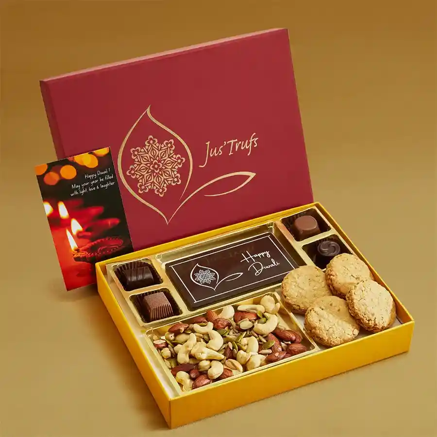 Festive gift box containing a Happy Diwali Chocolate Bar, four assorted truffles, a Healthy Nut Punch, and Whole Wheat Oats and Jaggery Cookies, decorated for Diwali celebration.