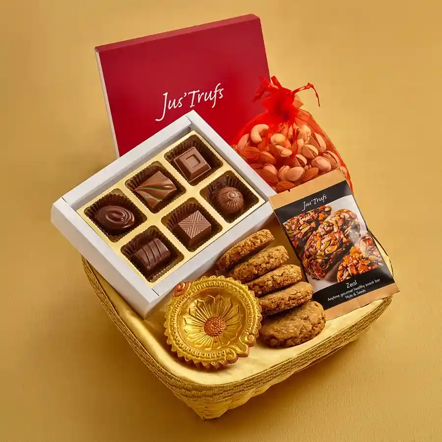 A beautifully arranged hamper filled with festive treats, including truffles, a mix of nuts and raisins, wholewheat and oats cookies, and an energy bar, conveying a sense of celebration and healthy indulgence.