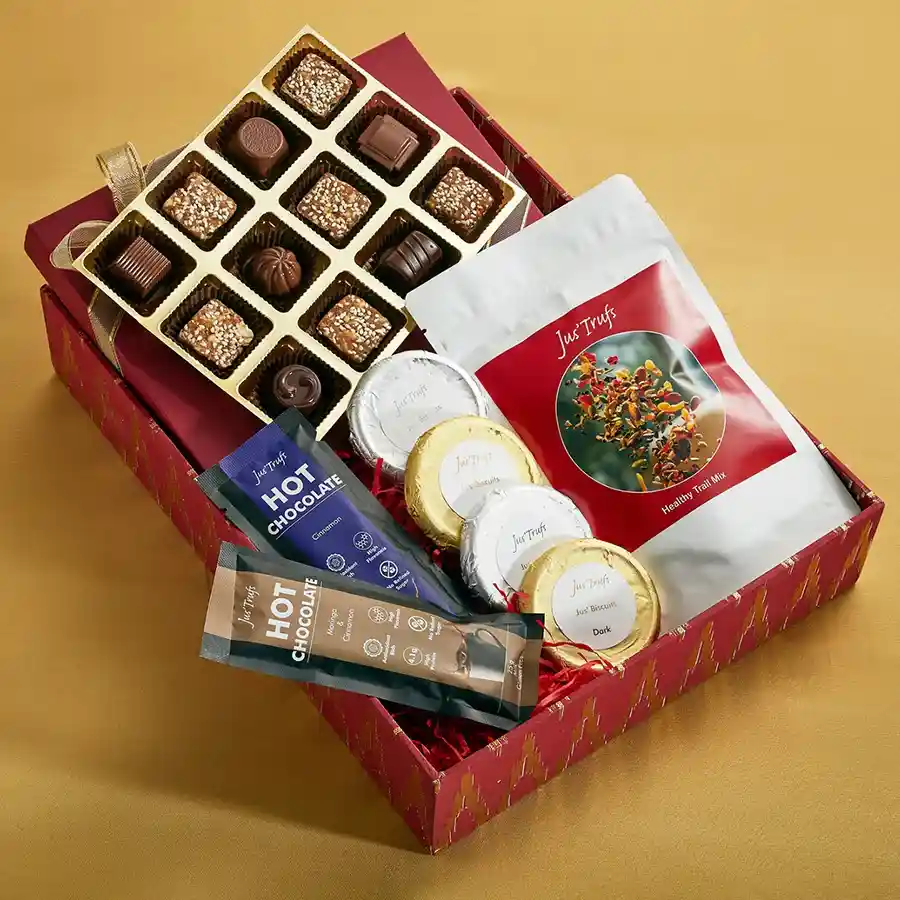 Festive Chocolate Gift Collection featuring truffles, vegan mithai, Zeal Bars, chocolate-coated biscuits, trail mix, and a personalized message card