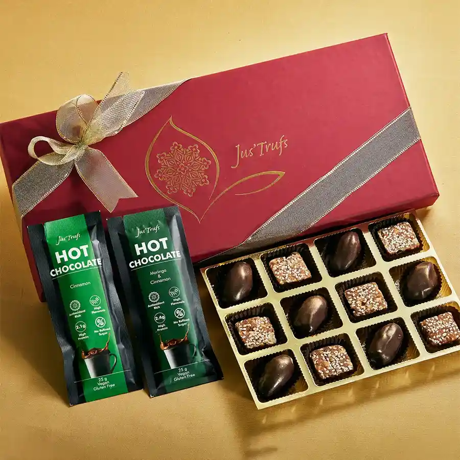 Guilt Free Diwali Vegan Collection featuring dark chocolate-coated dates, vegan mithai, hot chocolate mix sachets, and a message card in an elegant box