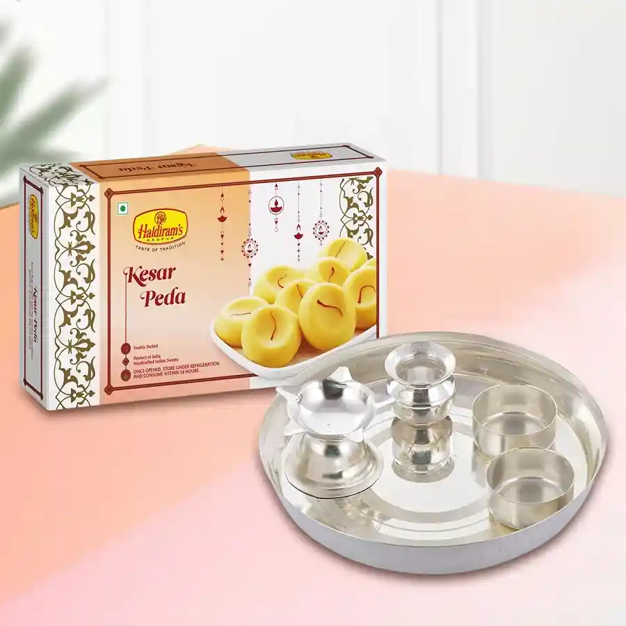 Haldirams Kesaria Pedas in a ½ kg pack alongside a silver-plated Aarti Thali