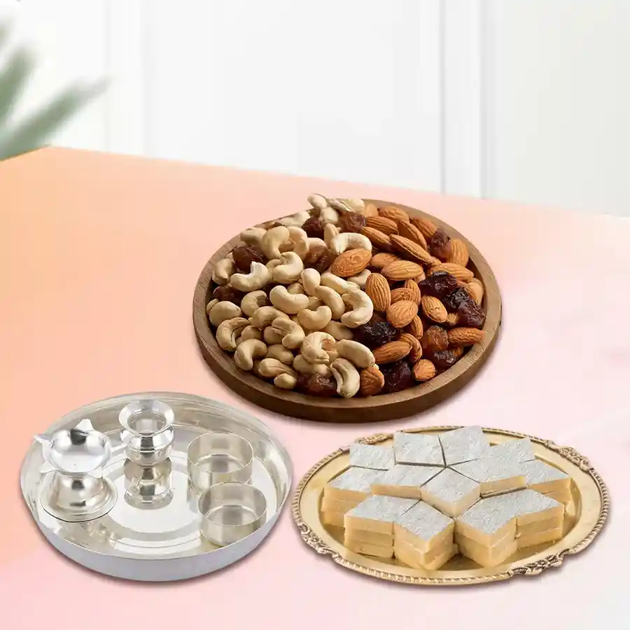Special silver plated puja thali with assorted dry fruits and Haldiram Kaju Katli on a decorative background