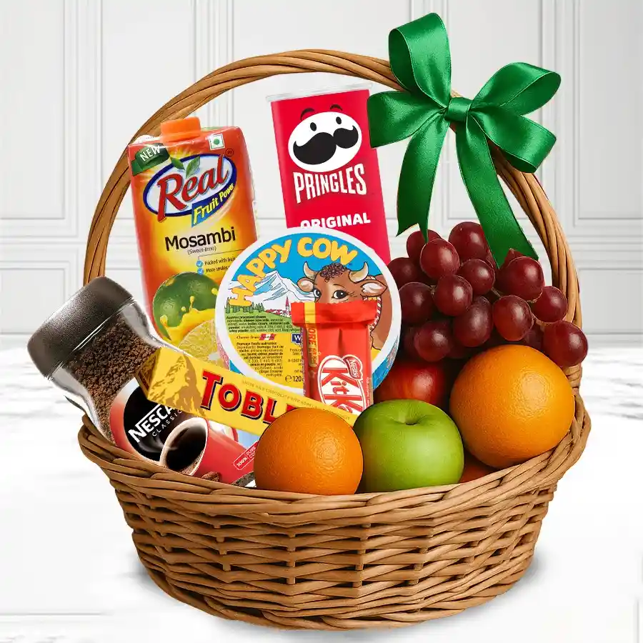 Gourmet fruit basket for Mother's Day filled with fresh fruits, chocolate, chips, cheese, coffee, and juice, beautifully arranged in a cane basket.
