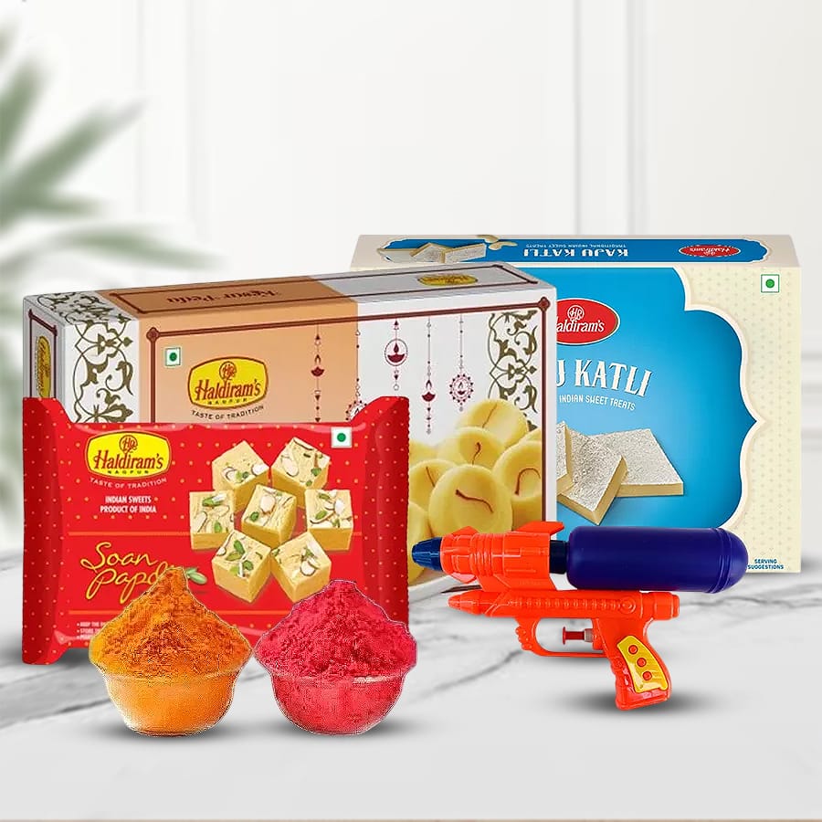 Haldiram's Dulcet Gladness Composite gift pack for Holi featuring Soan Papdi, Kesar Peda, Kaju Katli, a pichkari, and herbal gulal