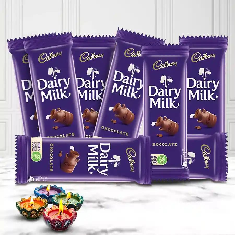 Assortment of chocolate gifts featuring Cadbury Dairy Milk chocolates, decorative mud diyas, and a beautiful tray for Diwali celebration.
