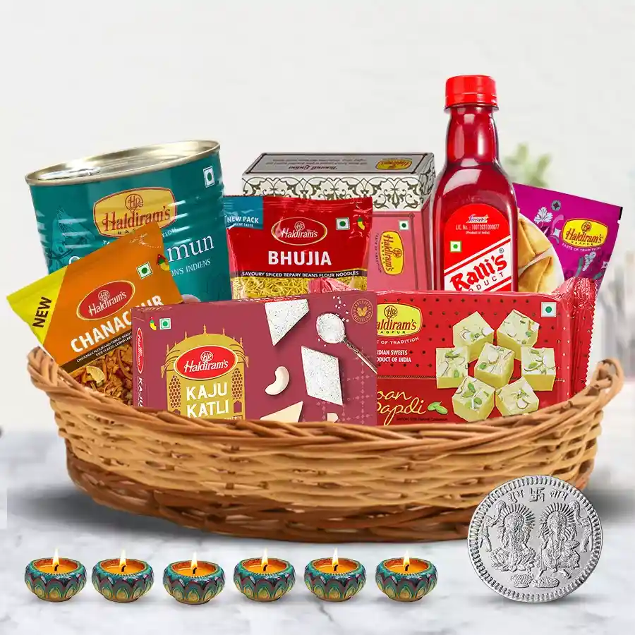 A festive Diwali hamper filled with sweets, snacks, diyas, and a Lakshmi Ganesh coin.