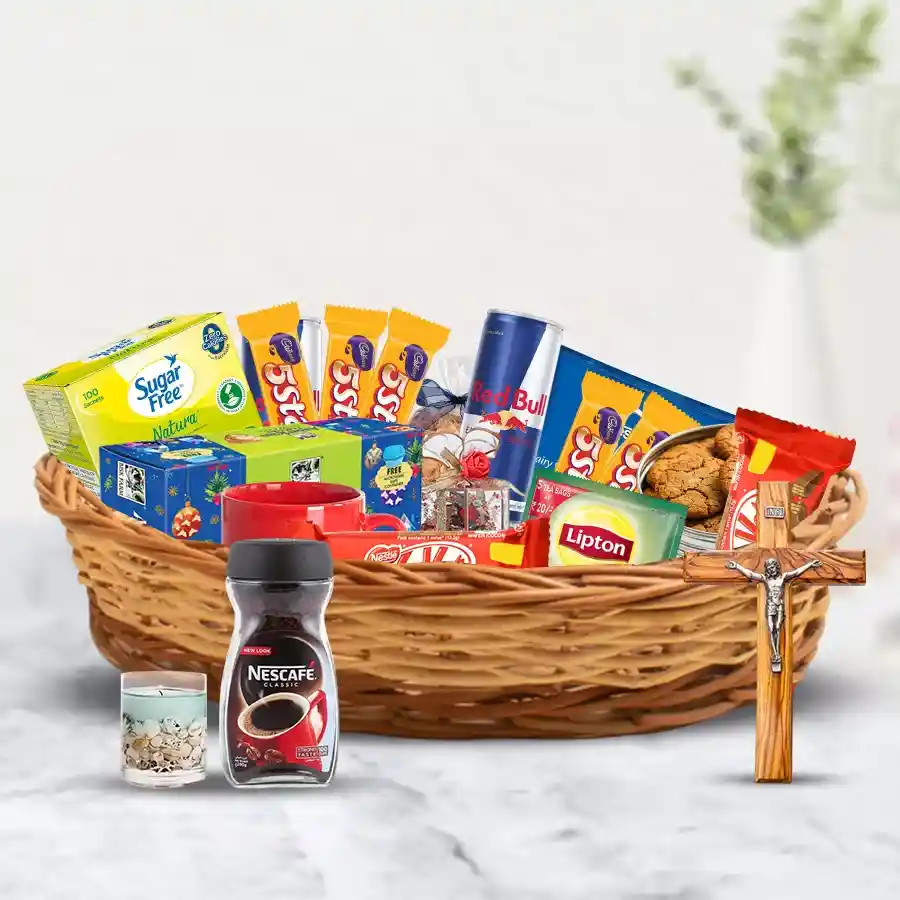 Taste of Christmas Gift Hamper filled with festive treats including fruit cake, chocolates, cookies, tea, coffee, candles, Red Bull, Sugar Free Natura, and a crucifix in a charming cane basket.