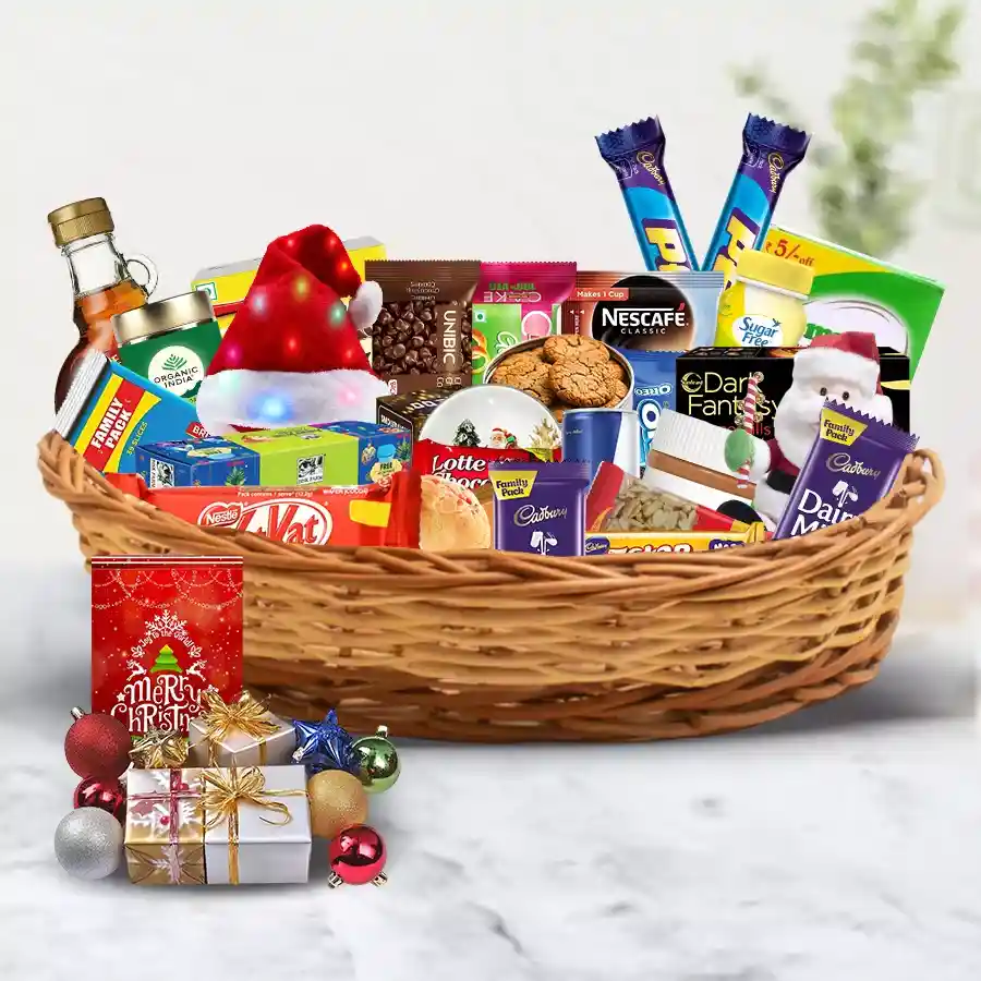 A beautifully arranged Christmas basket filled with fruit cakes, assorted biscuits, chocolates, gourmet snacks, peanut butter, cheese, premium teas and coffees, decorated with Santa-themed items and LED lights.