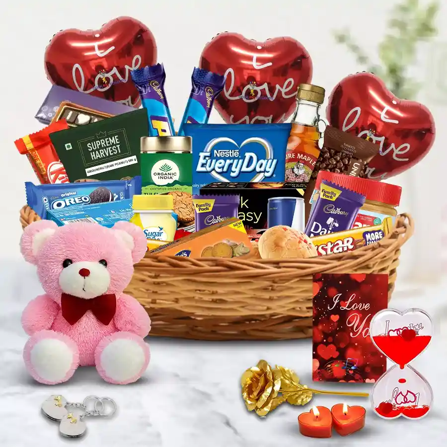 Valentine's Day gift basket featuring ginger biscuits, peanut butter, assorted chocolates, gourmet cookies, organic tea, rich coffee, love messages, a golden rose, a teddy bear, and heart-shaped keepsakes, all arranged in a stylish cane basket.