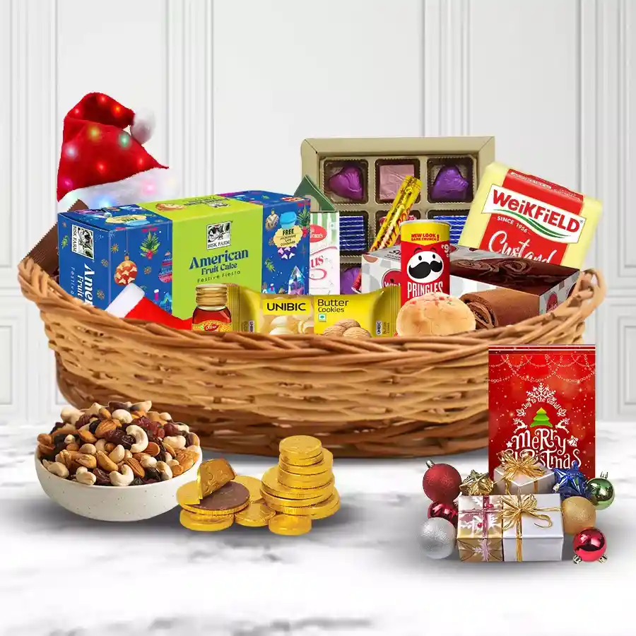 Decorative Christmas Hamper filled with festive treats including fruit cake, biscuits, Pringles, Swiss Rolls, chocolates, honey, LED lights, Santa stockings, and party poppers in a cane basket.