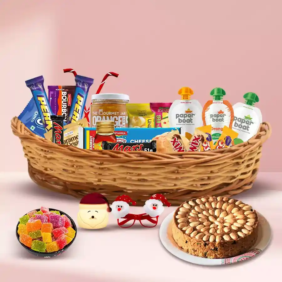 Yummy Christmas Treat Basket filled with Dundee Cake, caramel, Britannia cheeses, OREO, fruit cakes, assorted biscuits, Santa Goggles, LED Lamp, and classic chocolates from Mars and Twix.