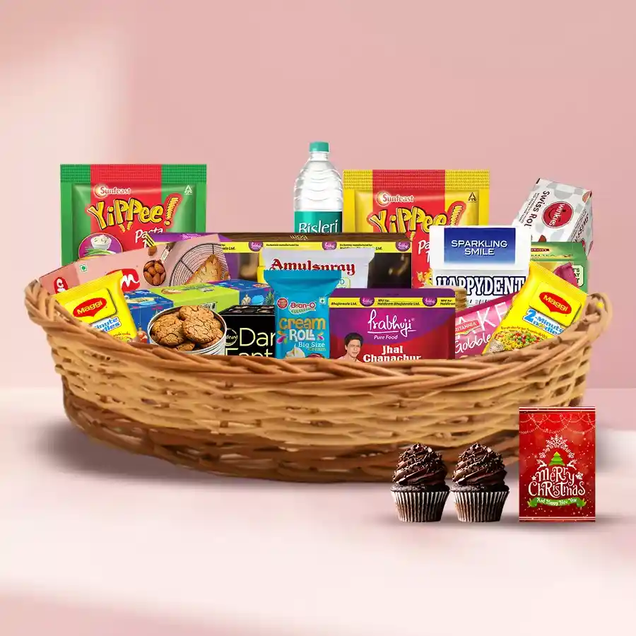 Christmas Attractive Gift Hamper filled with fruit cakes, biscuits, snacks, tea, honey, cupcakes, and festive essentials in a woven cane basket.