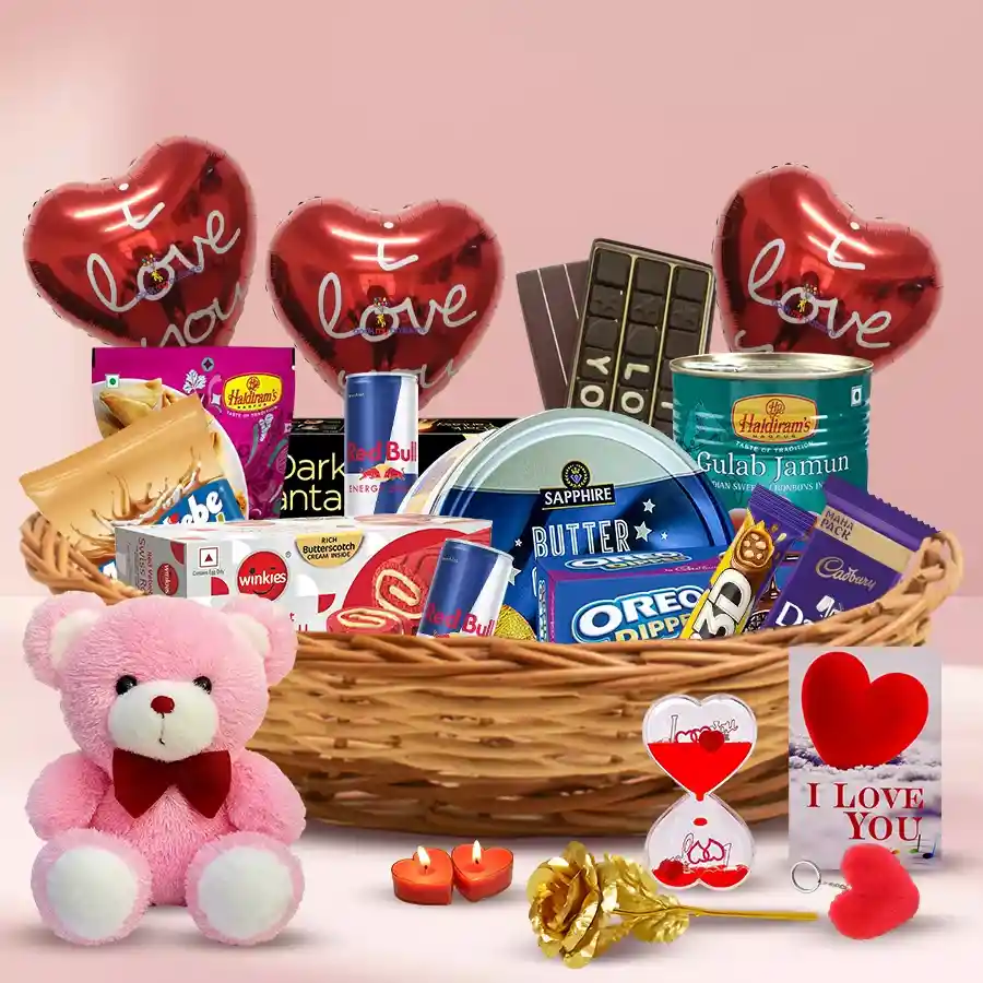 Exclusive Awaiting Valentine Gift Hamper with chocolates, biscuits, snacks, a golden rose, heart-shaped candles, a teddy bear, and a cane basket.