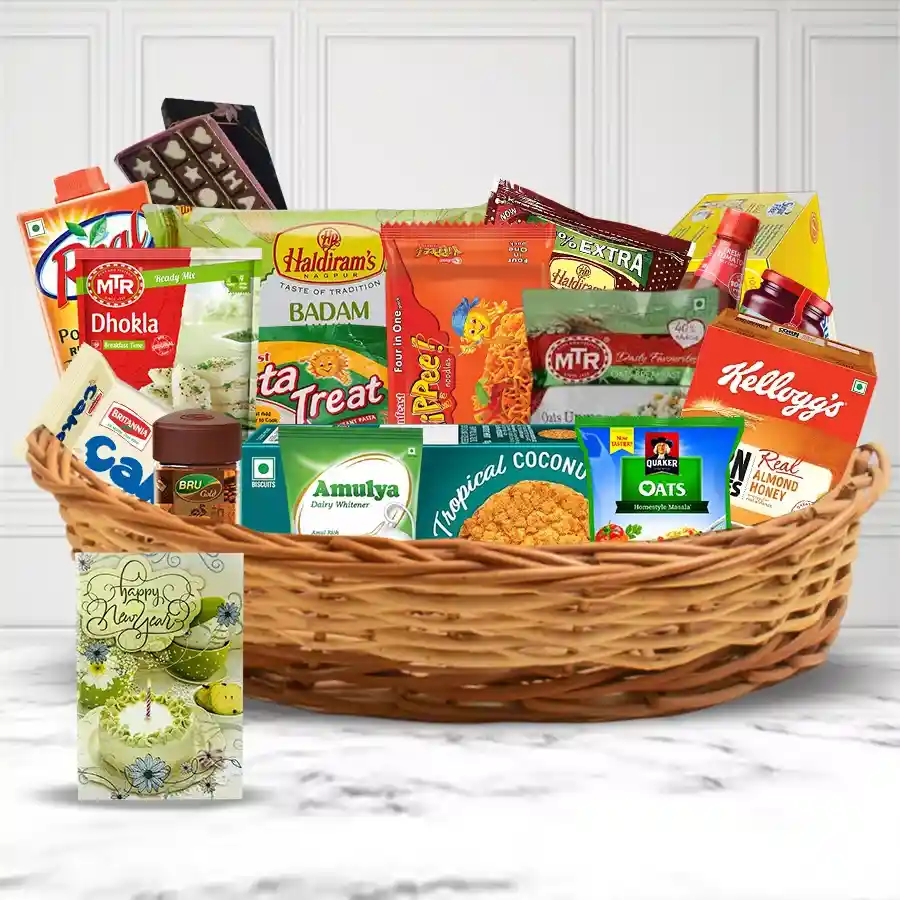 New Year gift hamper filled with Britannia cakes, Kellogg's Corn Flakes, Quaker Oats, MTR mixes, Haldirams snacks, Kissan jams, Bru Coffee, assorted sweets, savory treats, refreshing juices, and chocolates, accompanied by a greeting card.