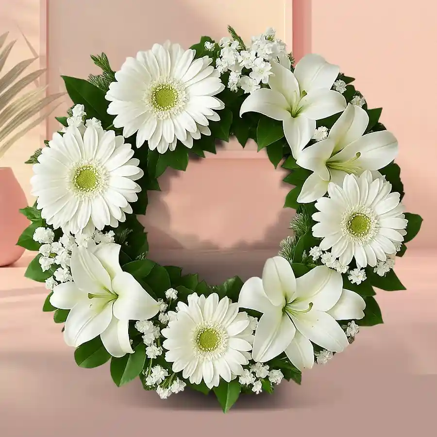 Beautiful white gerberas and lilies in a serene remembrance floral wreath.