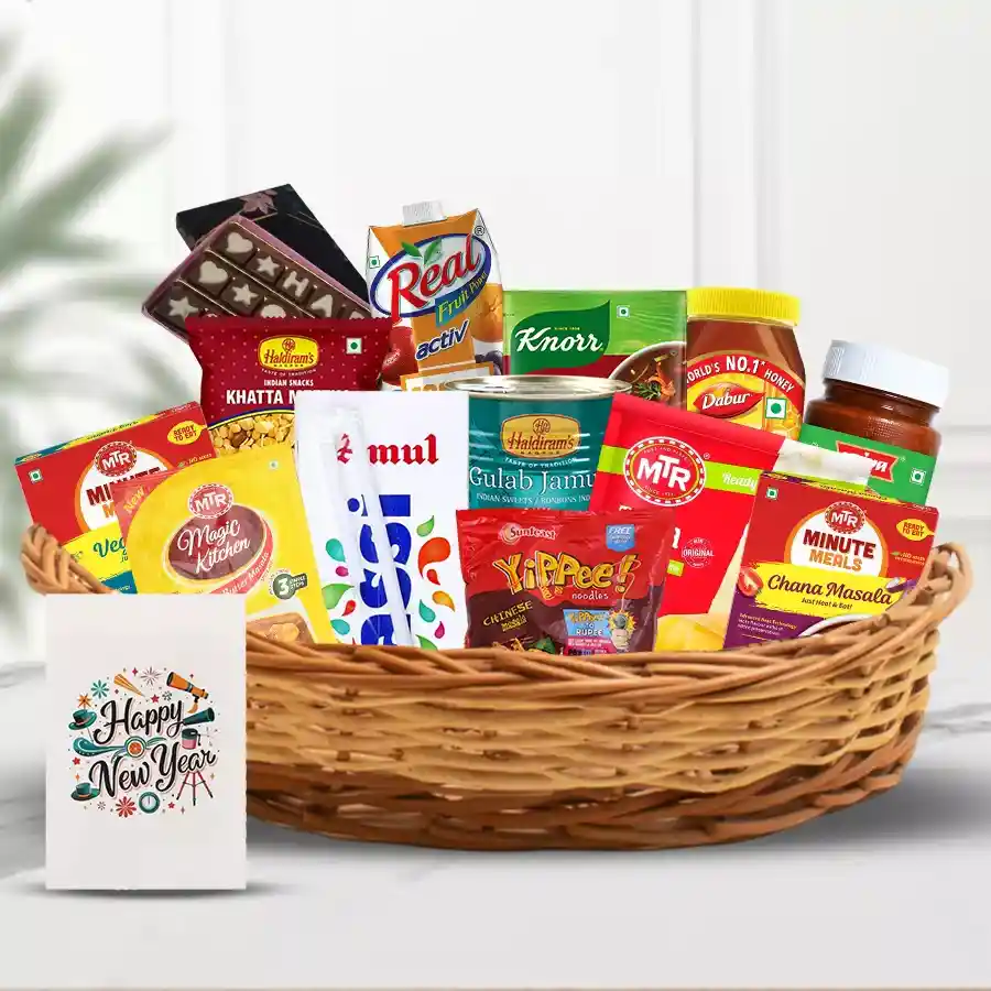 A vibrant gift basket filled with various food items including Amul Lassi, Sunfeast Yippee Noodles, MTR Paneer Butter Masala, Chana Masala, Vegetable Pulao, Haldirams snacks, Priya Tomato Pickle, Dabur Honey, Knorr hot & sour soup, Real Activ Juice, chocolates, and a New Year card.