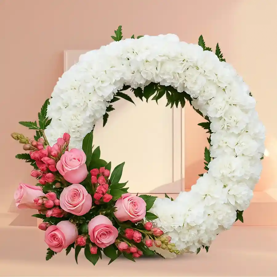 Heartfelt wreath featuring pink roses and white carnations for sympathy.