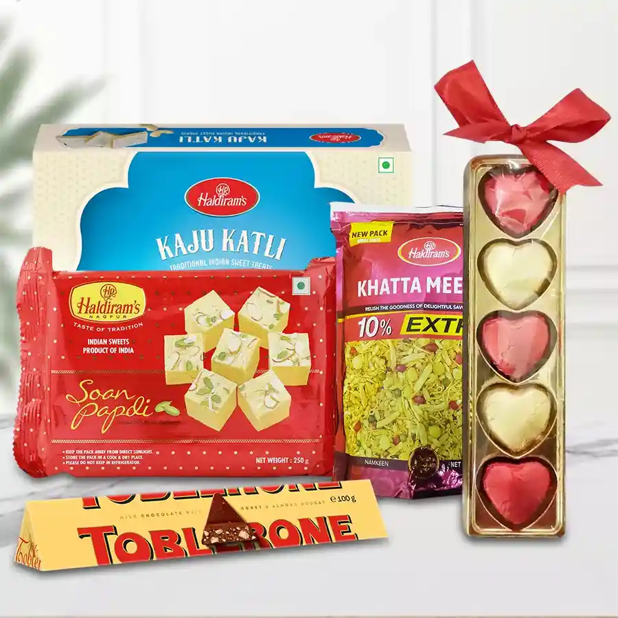 Delectable Haldirams Sweet N Savor Assortment gift box containing Soan Papdi, Khatta Meetha Mixture, Kaju Katli, Toblerone Chocolate, and heart-shaped homemade chocolates