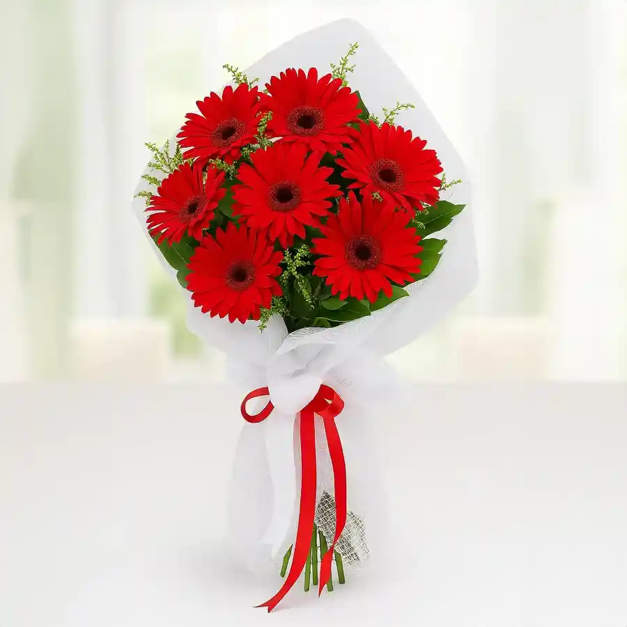 Bright red gerbera bouquet featuring ten vibrant blooms, elegantly tied with tissue.