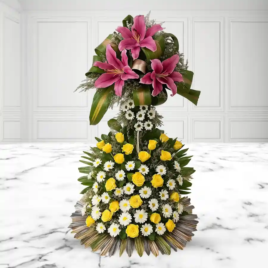 Stunning two-tier floral arrangement with pink lilies, yellow roses, and white chrysanthemums, wrapped in love.