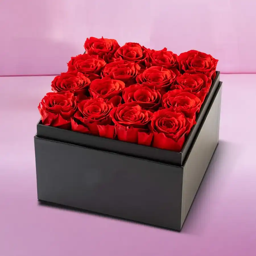 A stunning arrangement of 16 pink roses in a sleek black cardboard gift box, perfect for gifting.