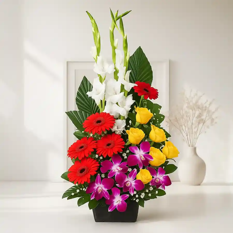 A stunning floral arrangement featuring red carnations, gerberas, yellow roses, white gladiolus, and blue orchids, creating a vibrant display.