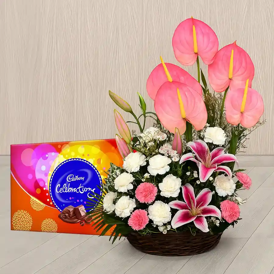Exclusive white and pink flower arrangement with chocolates, featuring Pink Lilies and Carnations.