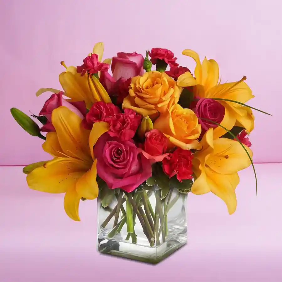 Elegant glass vase filled with assorted roses and pink lilies.