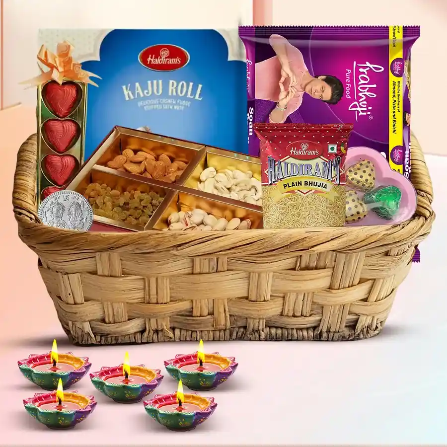 Diwali celebration gift hamper featuring traditional sweets, dry fruits, handmade chocolates, decorative diyas, and a silver-plated Laxmi Ganesh coin arranged in a decorative basket.