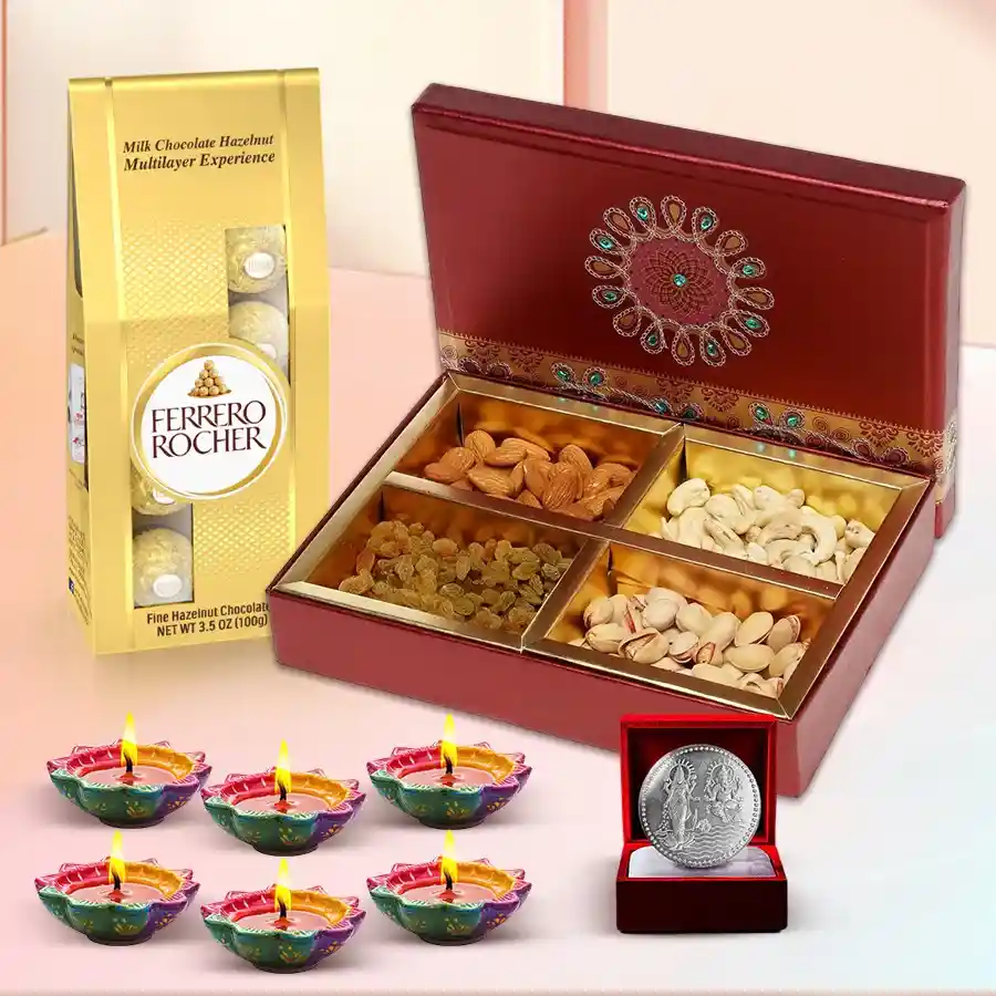 Diwali gift hamper featuring Ferrero Rocher chocolates, premium dry fruits, decorative diyas, and a silver-plated Lakshmi Ganesh coin.