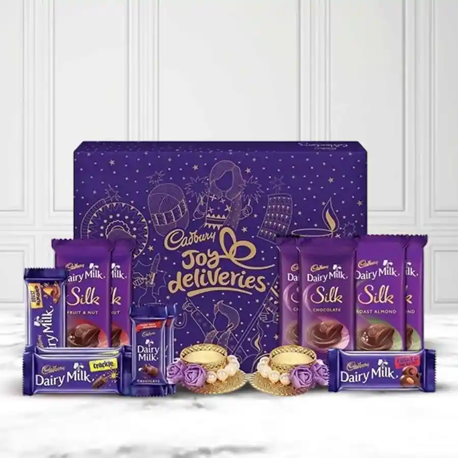 Assorted Dairy Delight Gift Set featuring various Cadbury chocolates and two decorated Mud Diyas