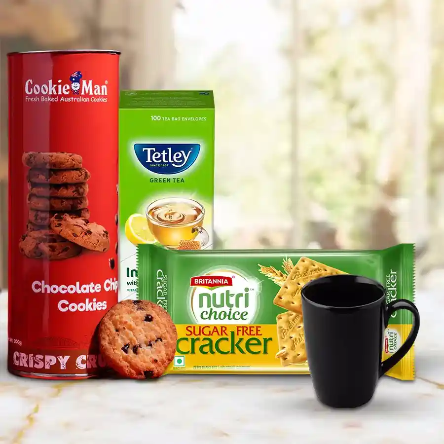 Healthy Tea Time Hamper with assorted cookies, green tea bags, cream crackers, and a coffee mug arranged beautifully