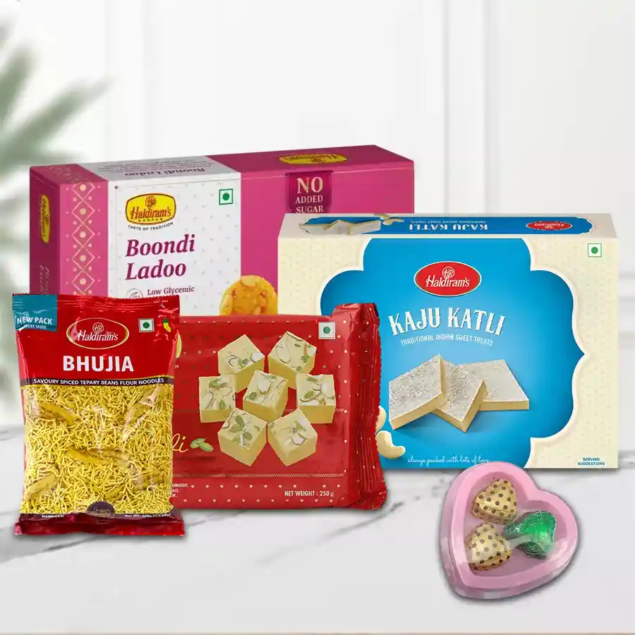 Haldirams Appetizing Gift Combo featuring Soan Papdi, Kaju Katli, Bhujia, Boondi Ladoo, and handcrafted chocolates in a heart-shaped box.