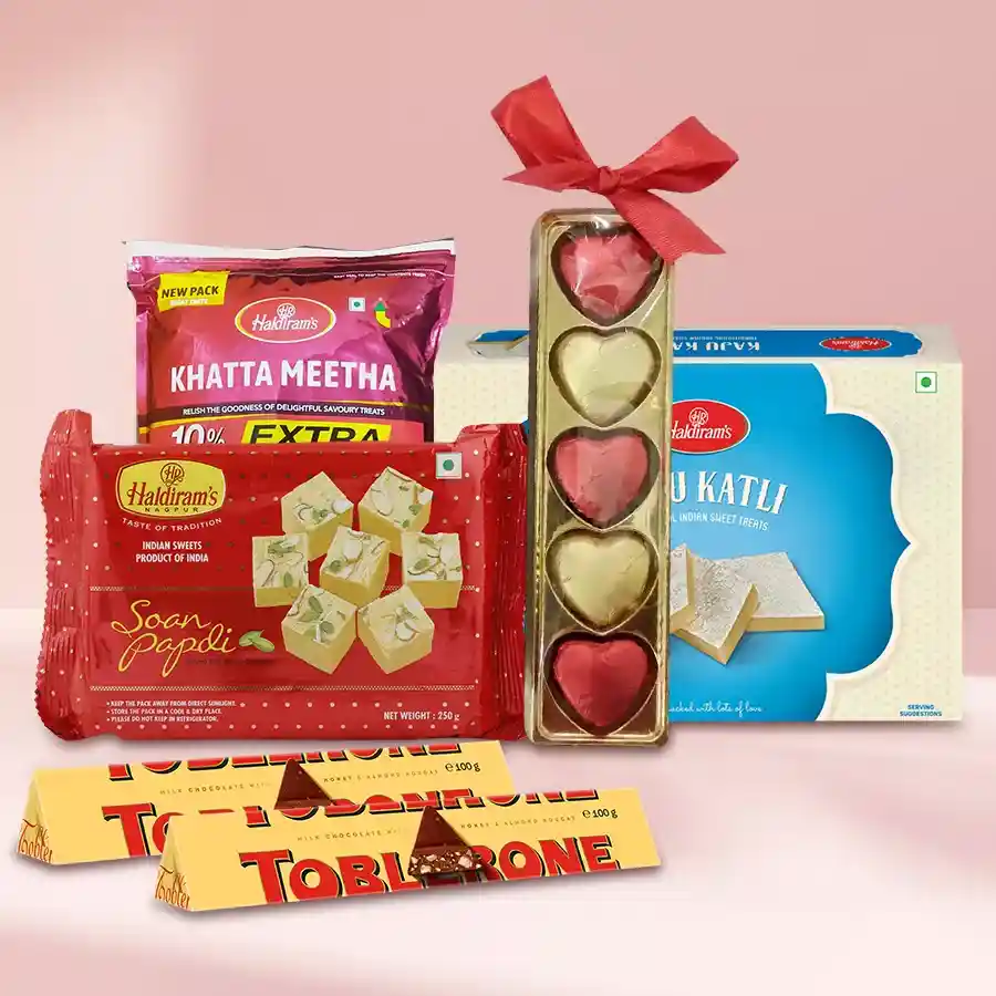 Haldirams Ambrosial Assortment pack featuring Soan Papdi, Kaju Katli, Khatta Meetha Mixture, Toblerone chocolates, and homemade treats