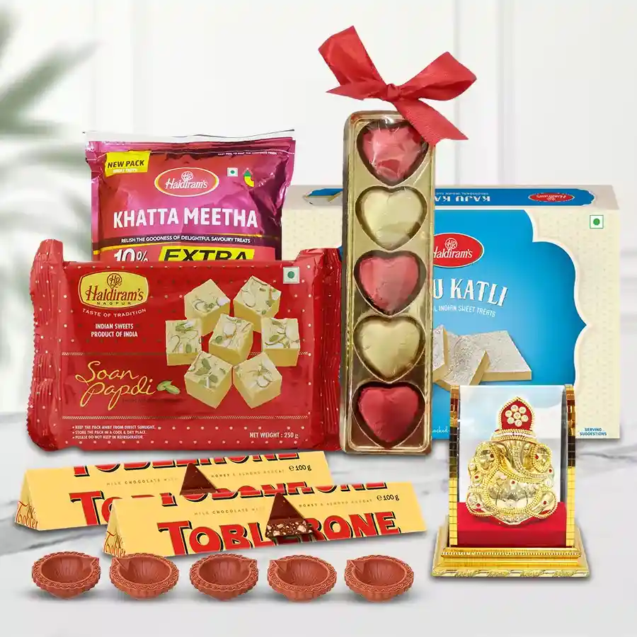 Tasty Haldirams Ambrosial Assortment gift hamper with sweets, chocolates, Mud Diyas, and Lord Vighnesh Idol for Deepavali celebrations.