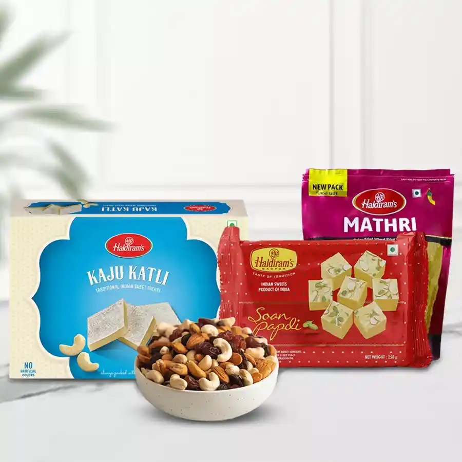 Arresting Hamper of Special Tidbits featuring assorted dry fruits, Haldiram Kaju Katli, Soan Papdi, and Haldiram Methi Mathri in an elegant presentation.