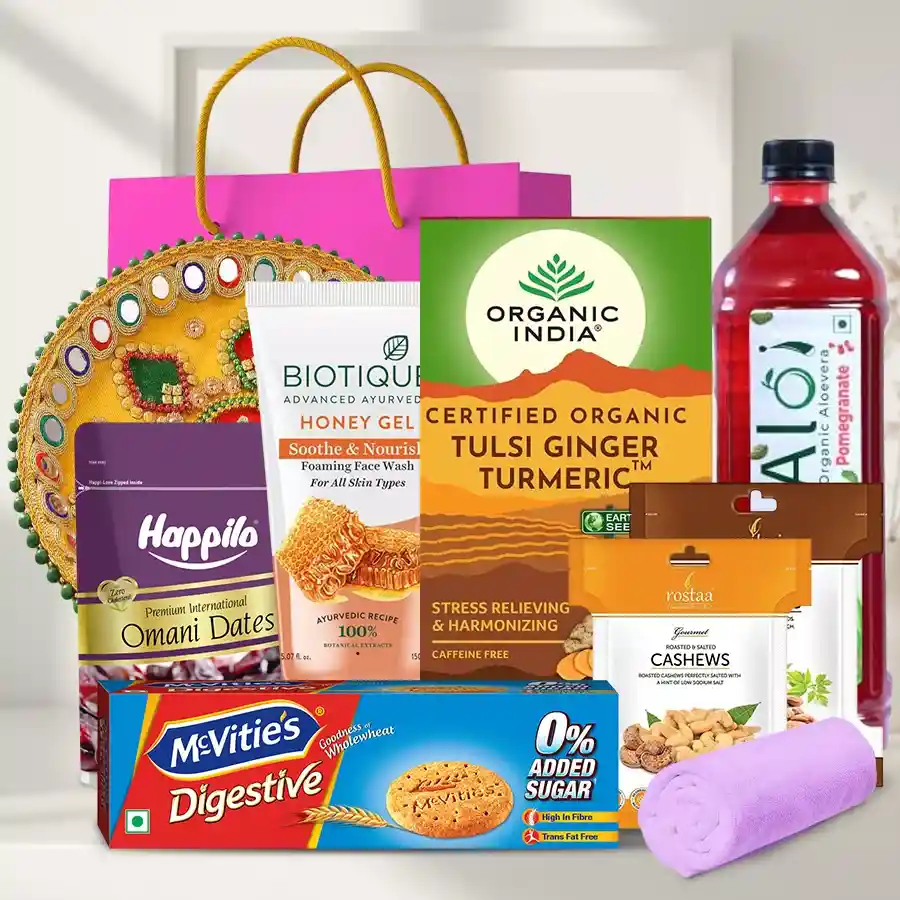 Rejuvenating Gift Hamper featuring Biotique Honey Gel Face Wash, Organic Tulsi Ginger Turmeric tea, Rostaa almonds and cashews, Alo Vera juice, McVities digestive cookies, premium Omani dates, a soft face towel, a designer pooja thali, and a gift bag.